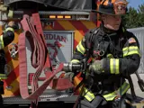 Firefighters pulling hose from a fire truck during a training exercise